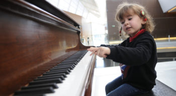 Adorable little girl having fun playing the piano
